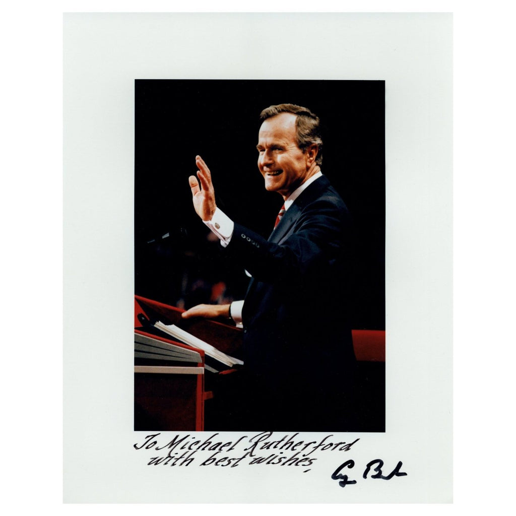 President George H. W. Bush standing at a podium waving to the crowd at the 1988 Republican National Convention.