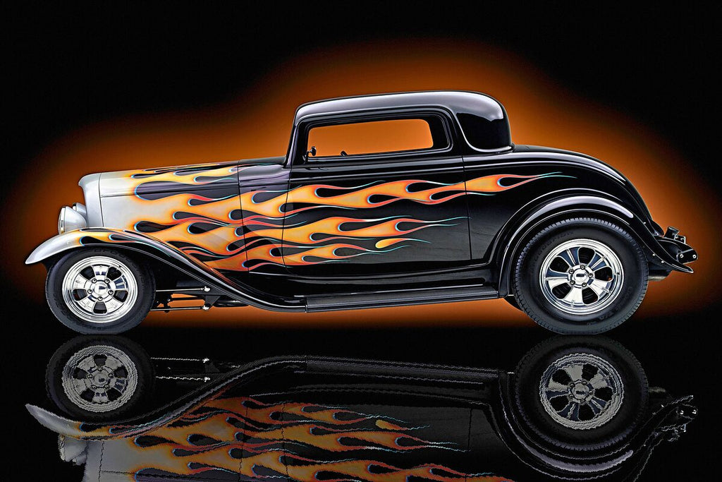 1932 Ford Coupe with yellow and orange flames in studio setting, polished chrome and reflection.