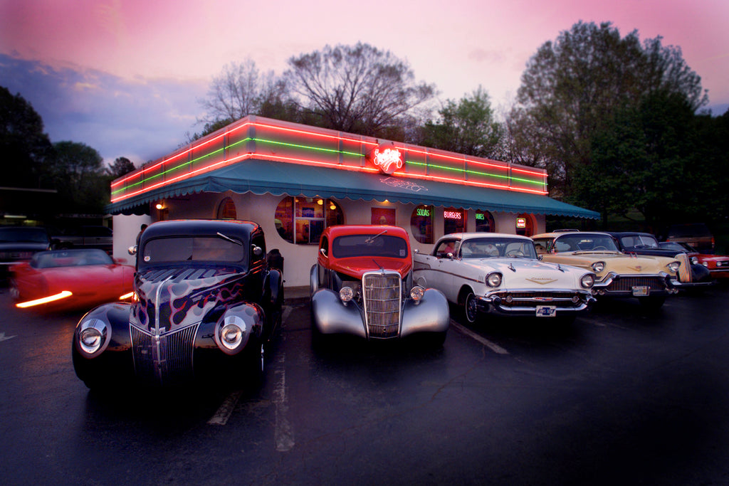 1940s and 1950s classic American cars illuminated by neon lights at a car show, photographed by Michael W. Rutherford.