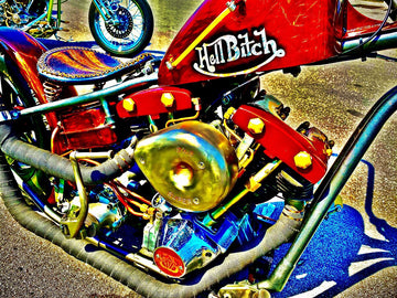 Custom red chrome motorcycle engine with S&amp;S air filter, polished accents, rugged leather seat, titled 'Hell Bitch' by Michael W. Rutherford.