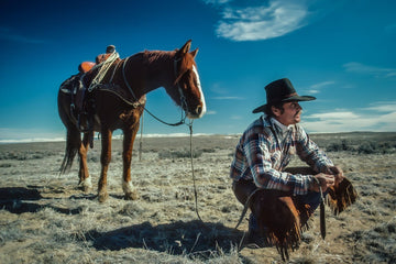 Limited edition print of an American cowboy with his horse in the vast landscape of the American West.