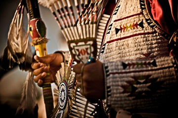 Close-up of Native American Crow Nation regalia featuring beadwork and eagle feathers.