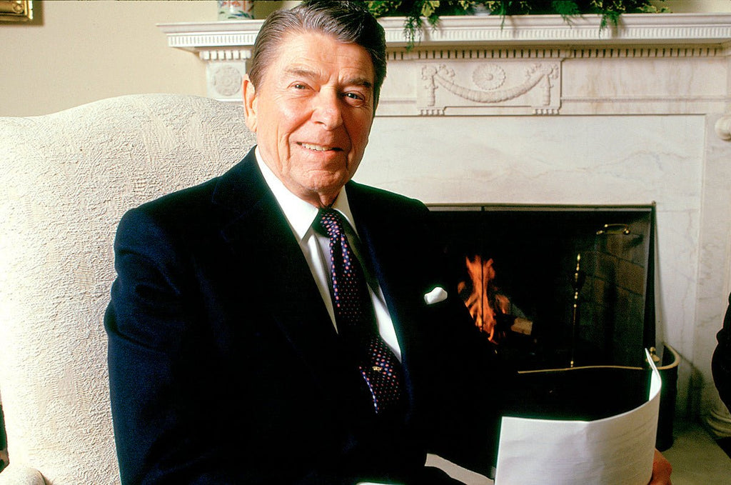 Ronald Reagan seated in the White House, taken by Michael W. Rutherford, capturing a reflective moment in history.