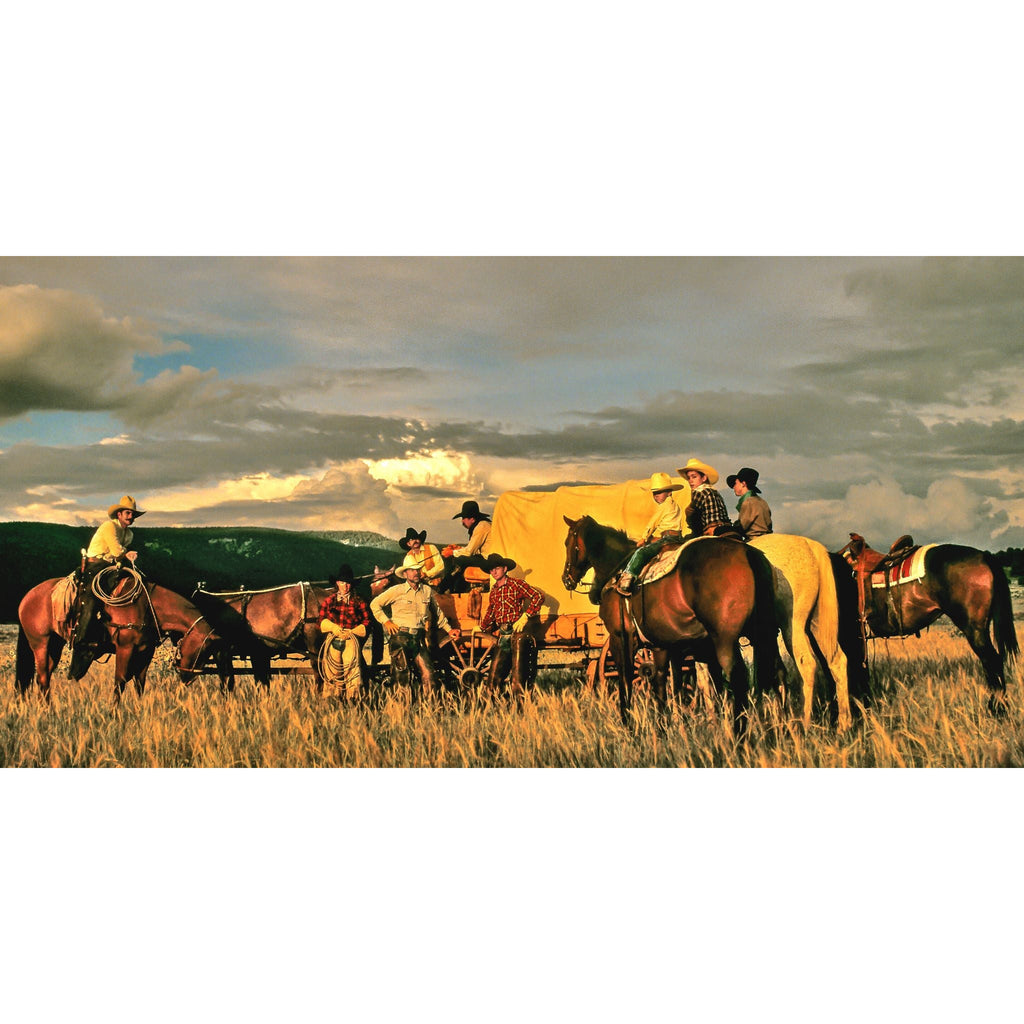 Cowboys and horses gathering around a chuck wagon in Montana.  Mountains are in background.