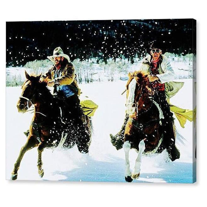Two cowboys, on horses, running in the snow.